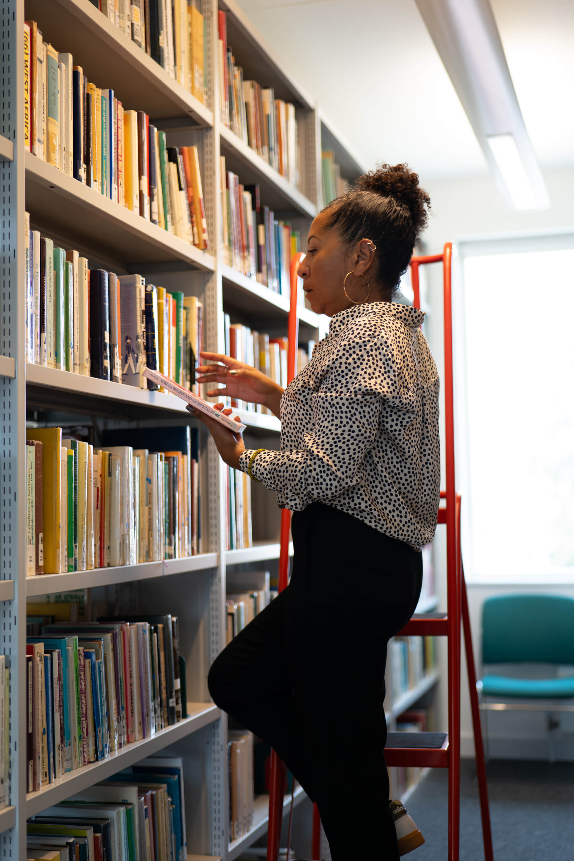 Diverse woman with books representing education leadership and innovation